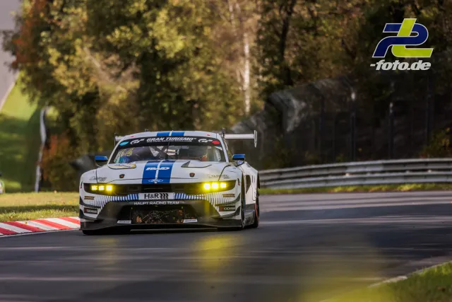 Weißer Ford Mustang GT3 mit blauem Mittelstreifen auf der Nordschleife, Herbststimmung mit Bäumen im Hintergrund