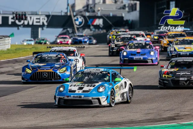 Einführungsrunde mit dichtem Feld auf der Nürburgring-Nordschleife, angeführt von einem Porsche 911 GT3 Cup in hellblau-weißer Lackierung.