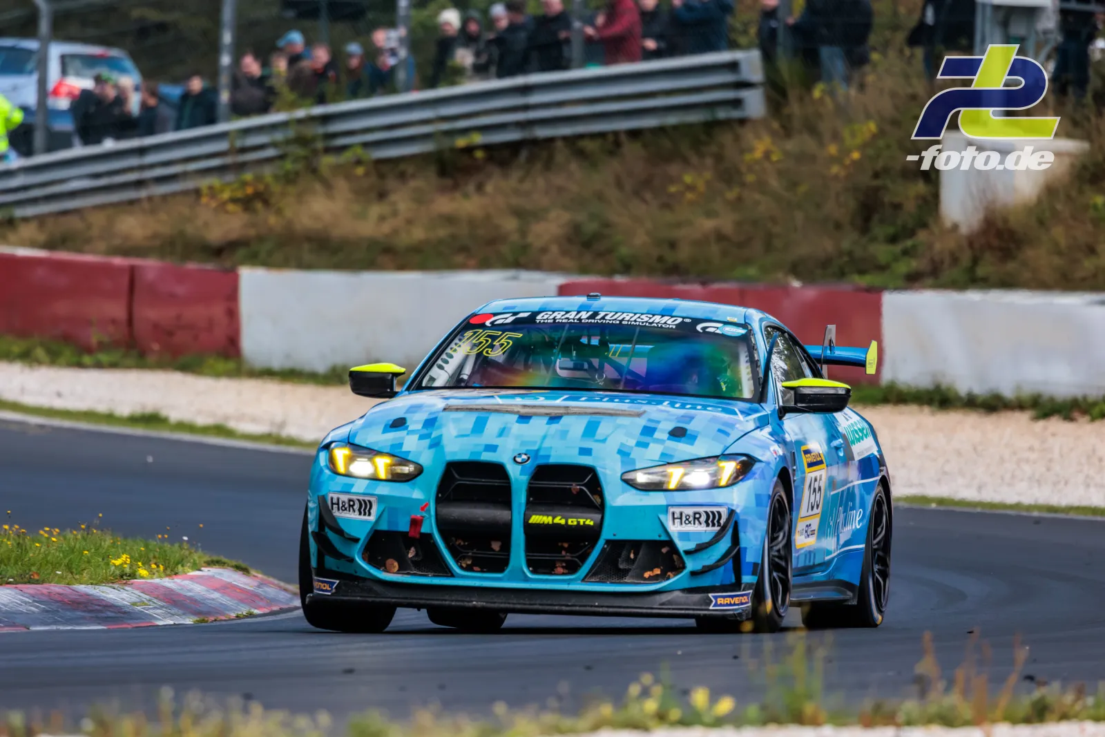 BMW M4 GT4 Nummer 155 von Plusline Motorsport in hellblauem Pixeldesign auf dem Nürburgring während des NLS-Rennens.