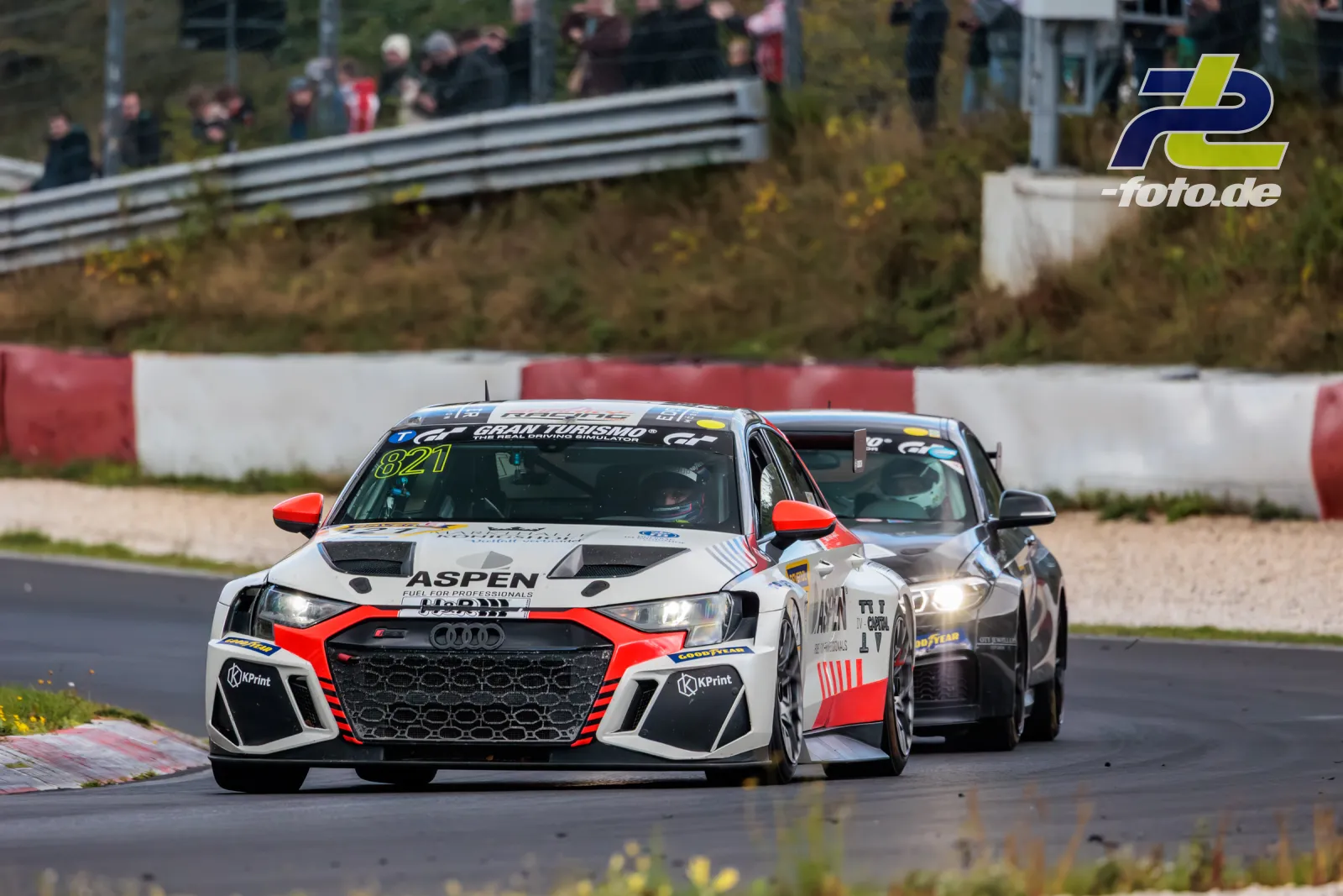 Audi RS3 LMS TCR mit Startnummer 821 im Zweikampf beim NLS-Rennen auf dem Nürburgring, Zuschauer im Hintergrund