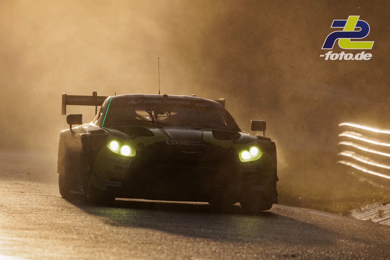 Aston Martin Vantage GT3 EVO #35 von Walkenhorst Motorsport im Qualifying auf dem Nürburgring, von Staubwolken umgeben bei dramatischem Gegenlicht.