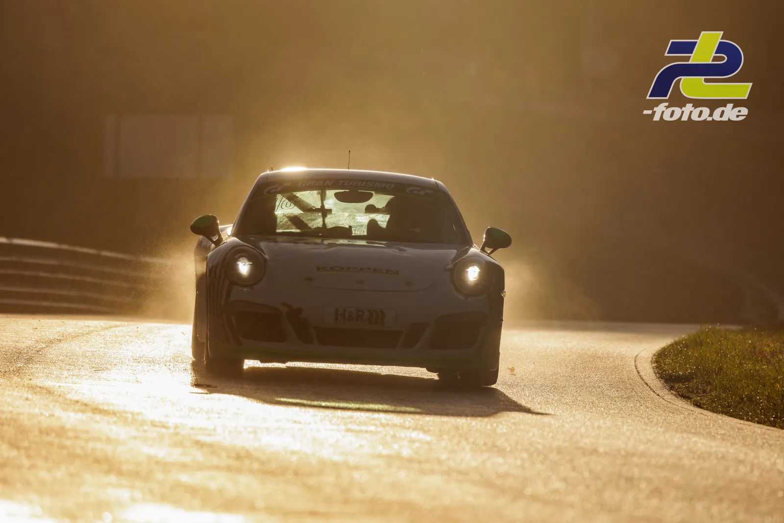 Porsche 911 im Gegenlicht während des Qualifyings beim NLS-Lauf am Nürburgring, goldene Lichtstimmung mit Staubaufwirbelung.