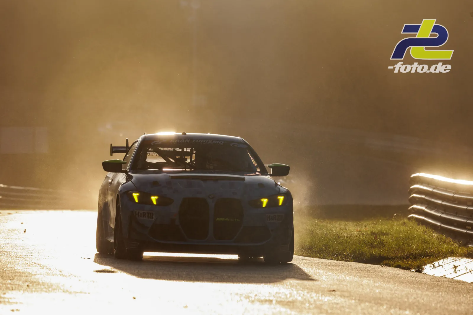 BMW M4 GT4 im Gegenlicht während des Qualifyings am Nürburgring, dramatische Lichtstimmung mit Staubwolken