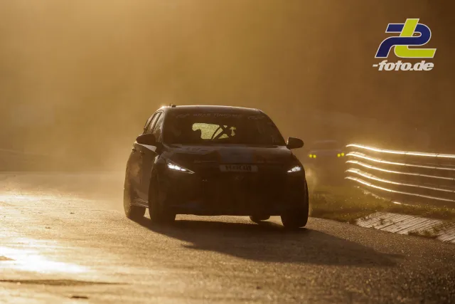 Rennfahrzeug in Frontalansicht bei Gegenlicht auf der Nordschleife, zweites Fahrzeug im Hintergrund während des Qualifyings