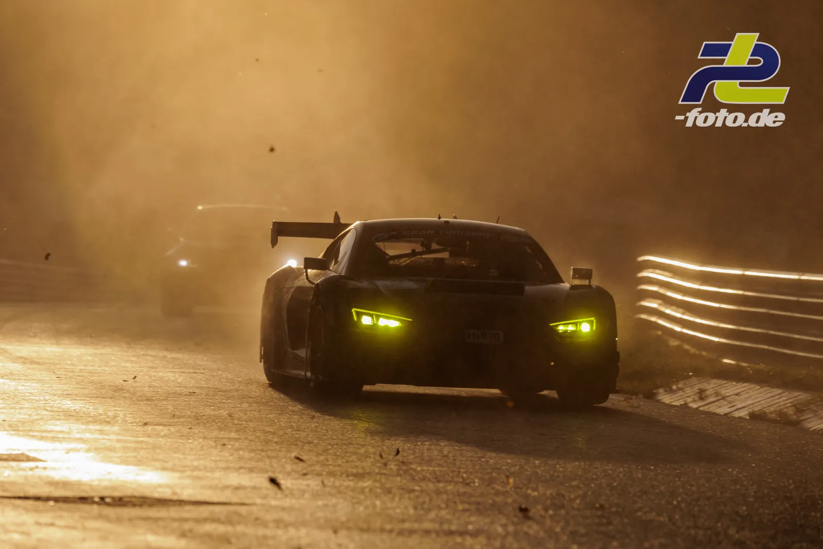 Audi R8 LMS GT3 EVO II im Qualifying bei dichtem Nebel auf dem Nürburgring, gelbe Scheinwerfer leuchten durch die Dämmerung.