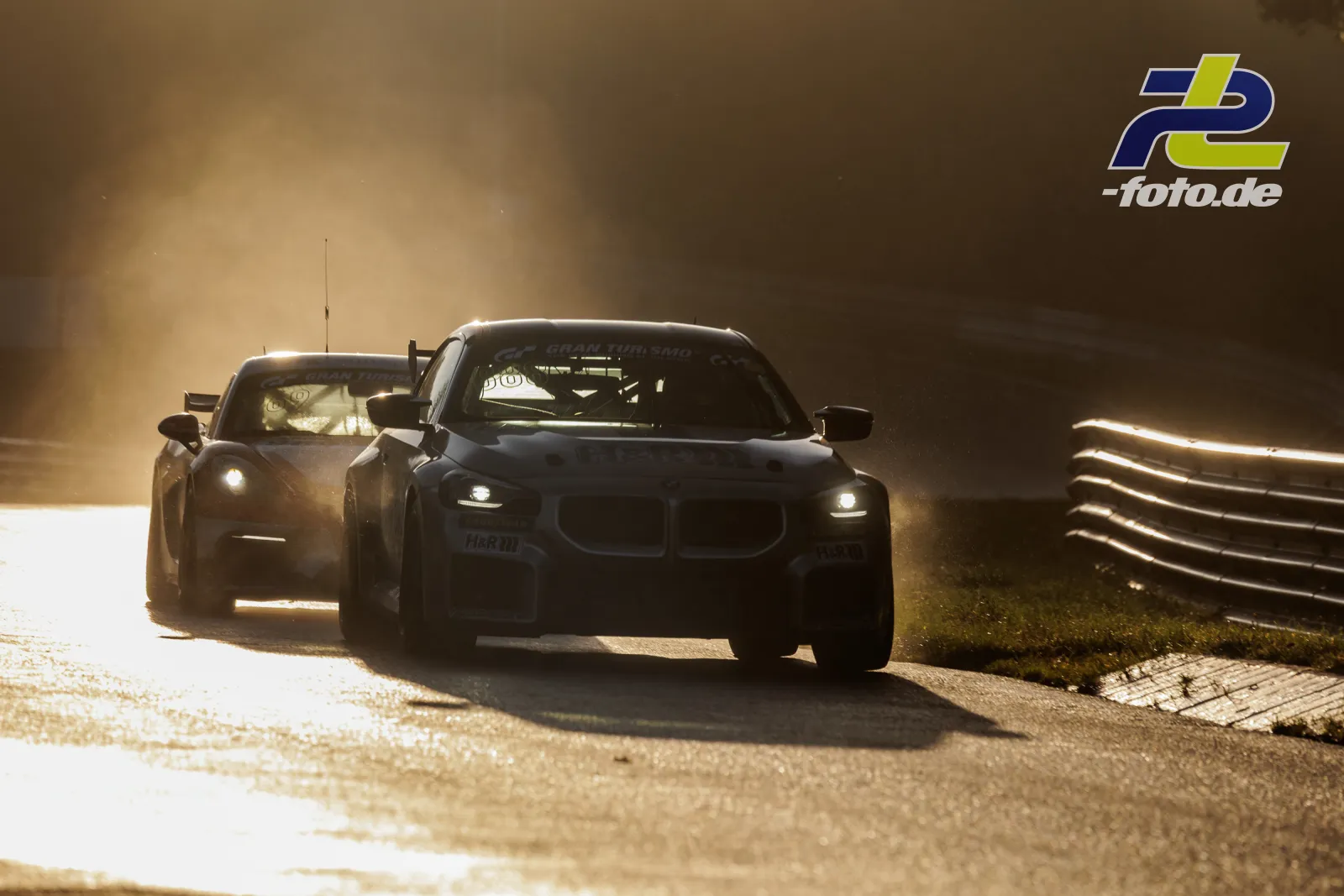 BMW M2 Racing im Gegenlicht auf der Nordschleife, dahinter ein weiteres Fahrzeug, staubige Atmosphäre während des Qualifyings der NLS.