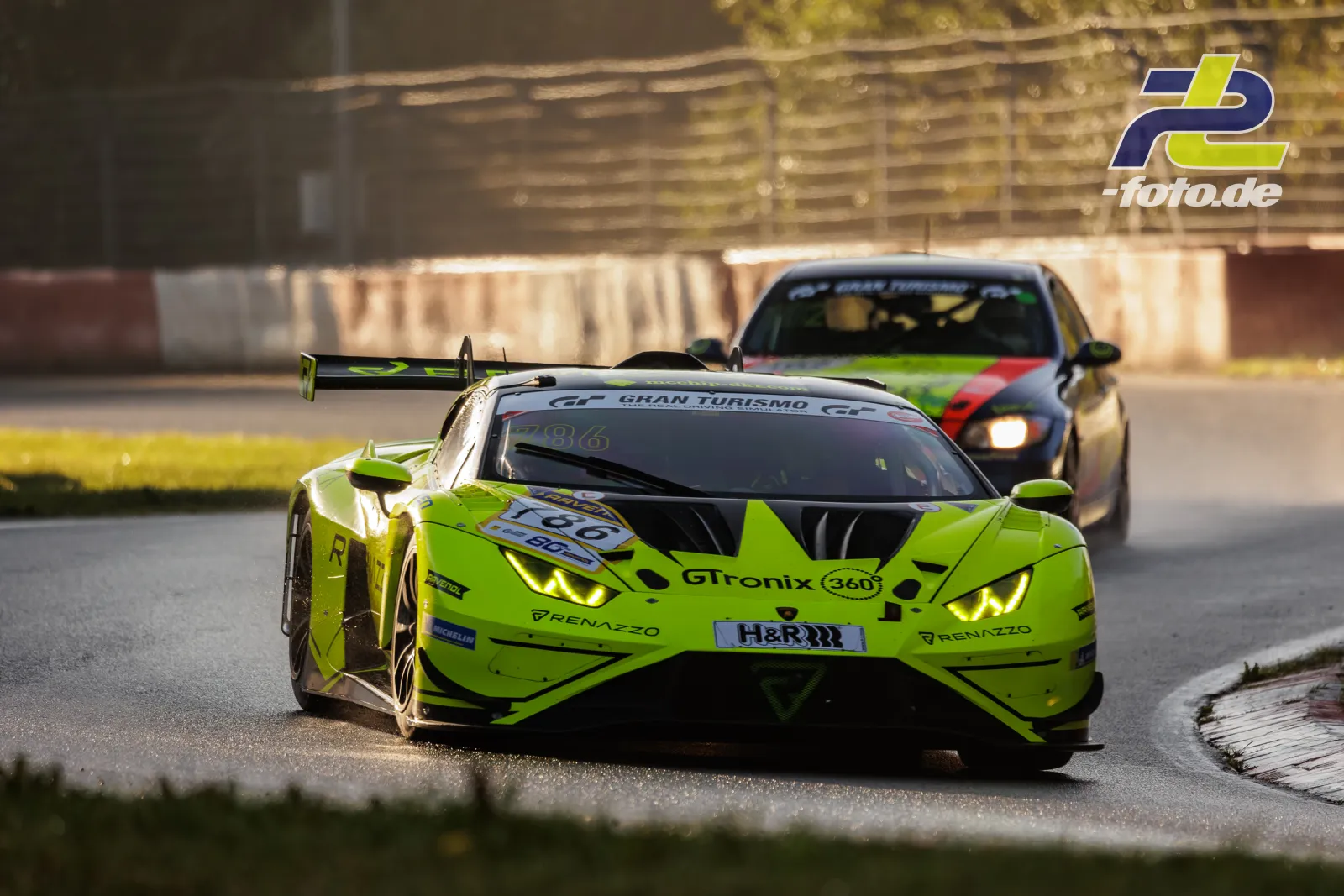 Ein neongelber Lamborghini Huracán GT3 mit der Startnummer 786 fährt in einer Kurve vor einem weiteren Fahrzeug auf dem Nürburgring.